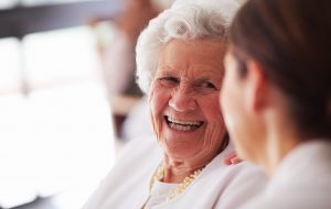 An elderly woman talking with her nurse